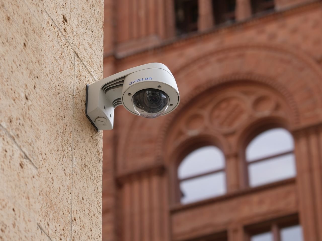 About Wall-mounted dome security camera on a city building, enhancing public safety.